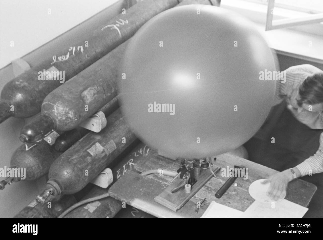 Mitarbeiter der Wetterdienststelle beim Aufblasen von einems Wetterballon, Deutschland 1930er Jahre. Mitarbeiter eines Meteorologischen Instituts Sprengen eines Registrierung Ballon, Deutschland 1930. Stockfoto