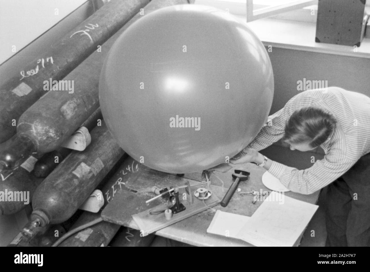 Mitarbeiter der Wetterdienststelle beim Aufblasen von einems Wetterballon, Deutschland 1930er Jahre. Mitarbeiter eines Meteorologischen Instituts Sprengen eines Registrierung Ballon, Deutschland 1930. Stockfoto