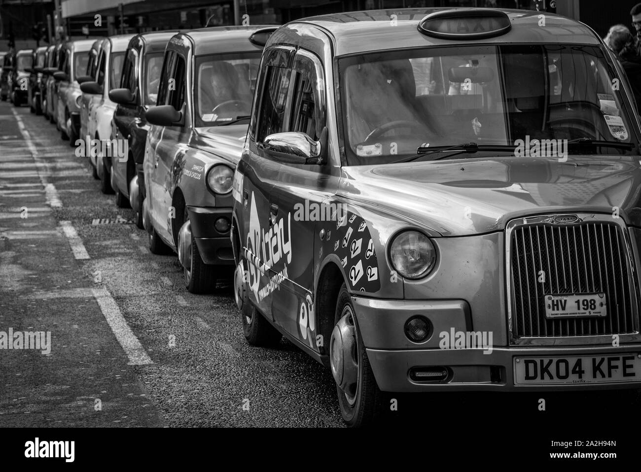 Linie der Autos auf der Straße in Manchester, UK, Schwarz und Weiß Stockfoto