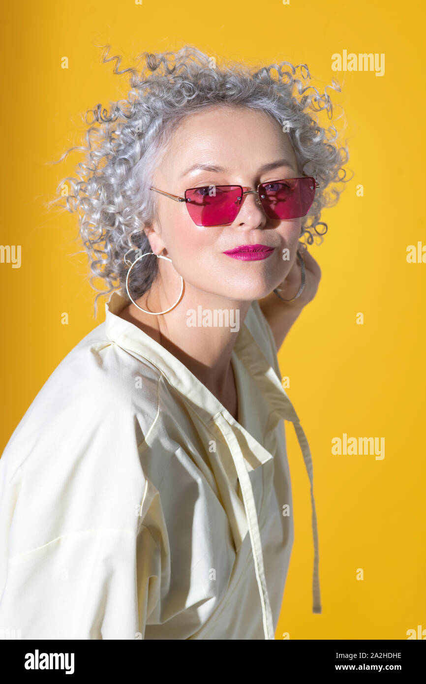 Pretty Woman tragen Ohrringe in der Nähe von Hintergrund posiert Stockfoto