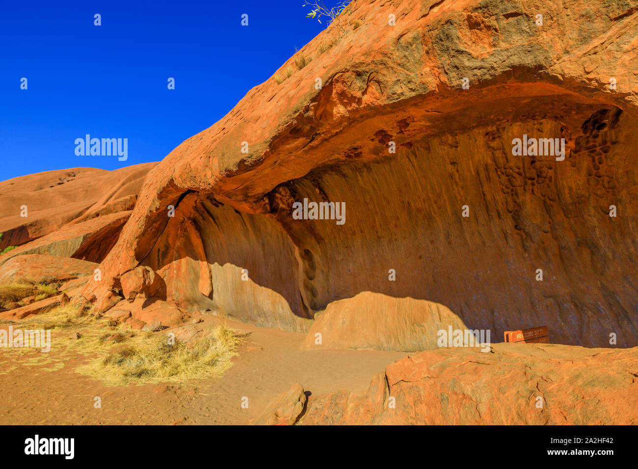 Beliebte Mala Spaziergang mit Wave geformte Felsformation an der Basis des Ayers Rock in den Uluru-Kata Tjuta National Park, Northern Territory, Australien. Red Centre Stockfoto
