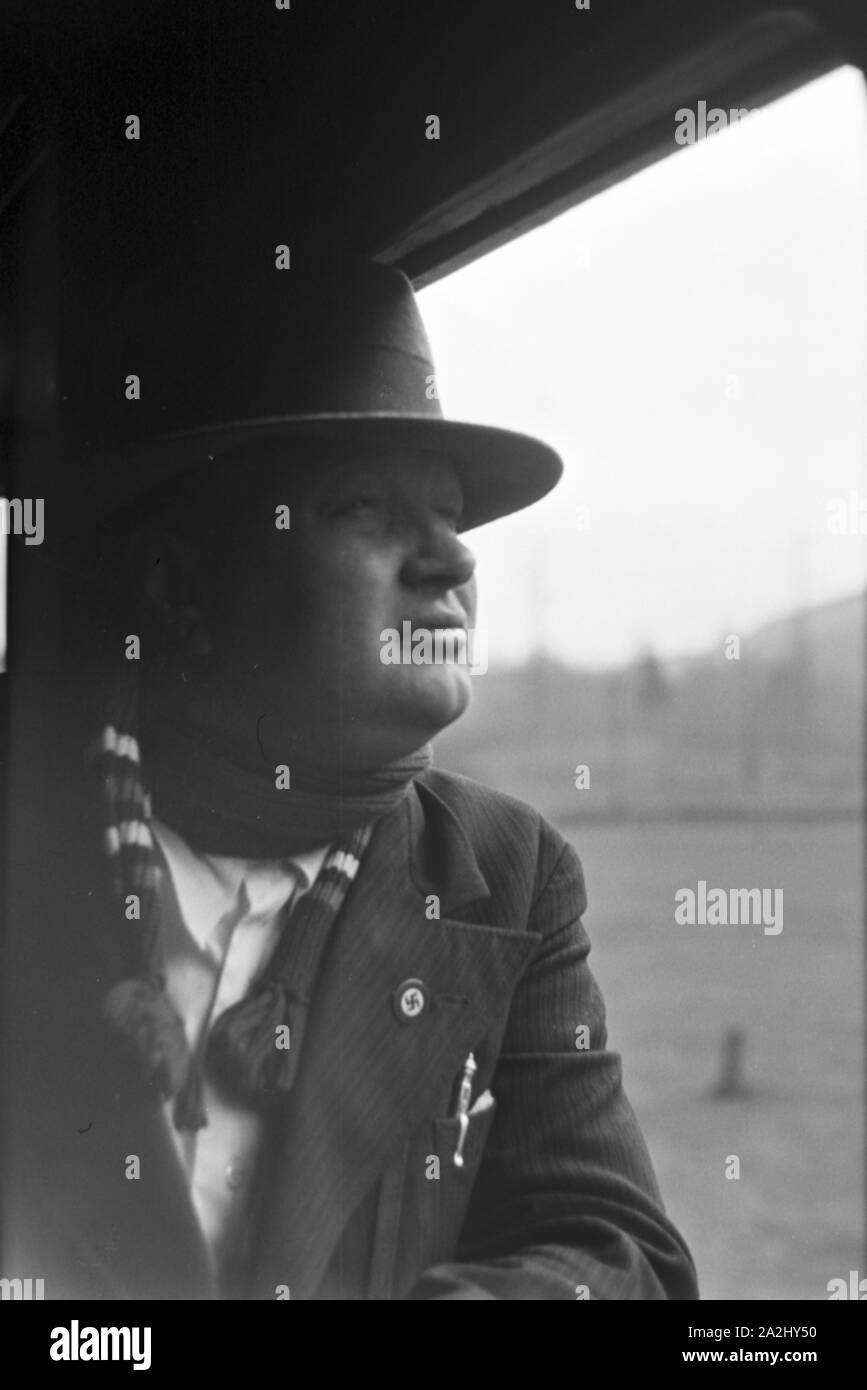 Ein parteimitglied der NSDAP mit dem Hakenkreuzabzeichen auf der Reise durch Italien, 1930er Jahre. Ein Nsdap-Mitglied mit einem Hakenkreuz Abzeichen auf einer Zugfahrt durch Italien, 1930. Stockfoto