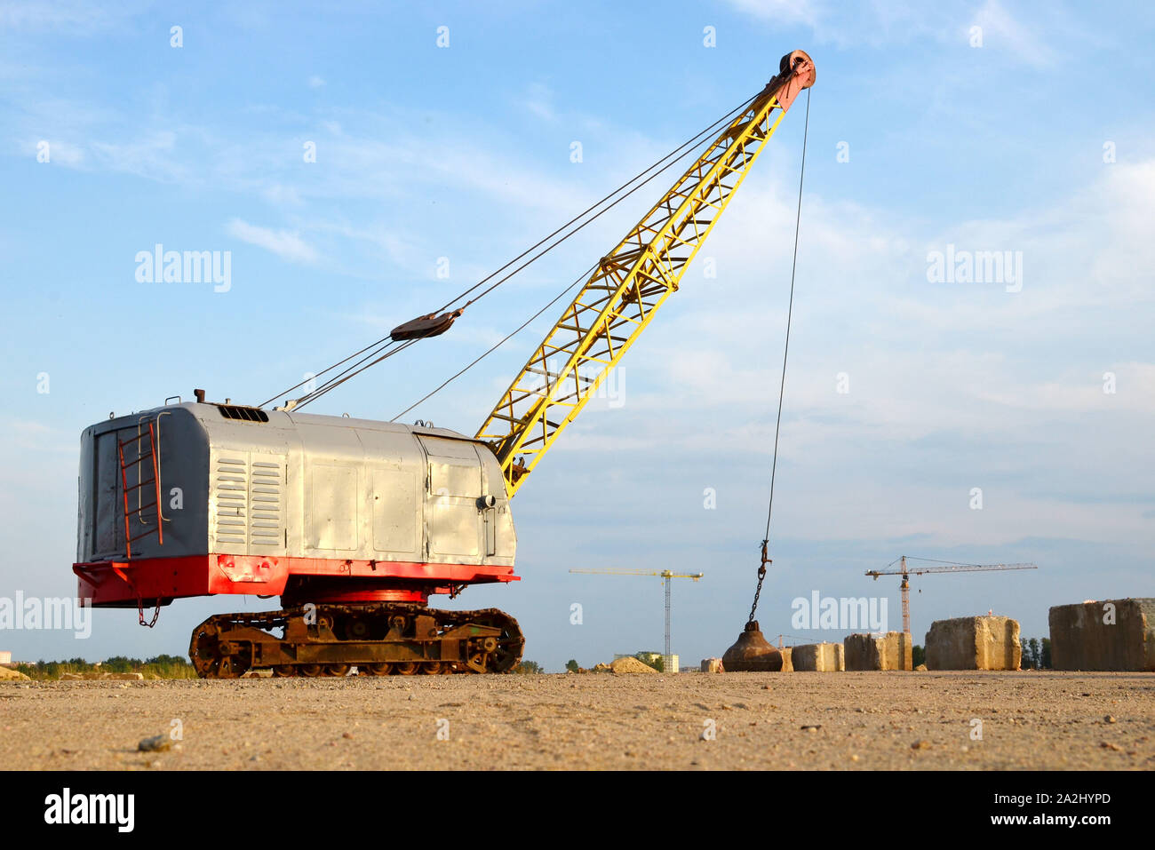 Große Raupenkran oder schleppschaufel Hydraulikbagger mit einem heavy metal Abrissbirne an einem Stahlseil. Wrecking Ball auf Baustellen. Demontage und Dm Stockfoto