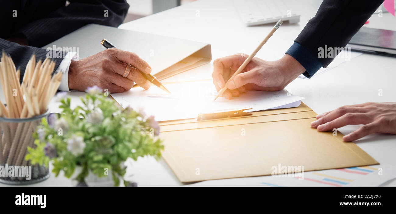 Nahaufnahme der Hand zwei Unternehmer diskutieren Reporting das Dokument auf dem Schreibtisch im Büro. Stockfoto