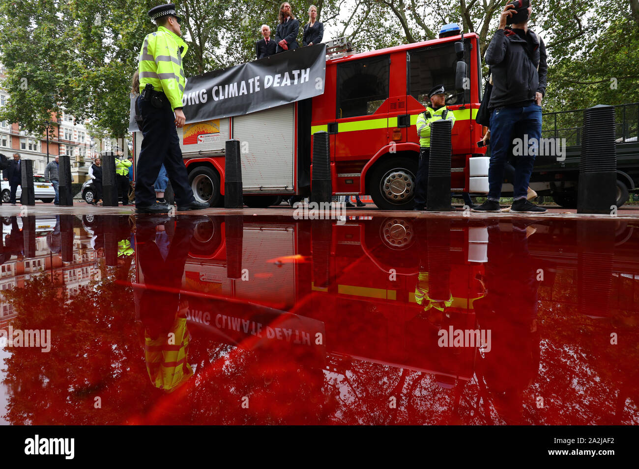 Polizisten außerhalb des Treasury Gebäude in Westminster, wo Aussterben Rebellion Mitkämpfer 1.800 Liter fake Blut von einem Feuerwehrauto gesprüht haben. Stockfoto