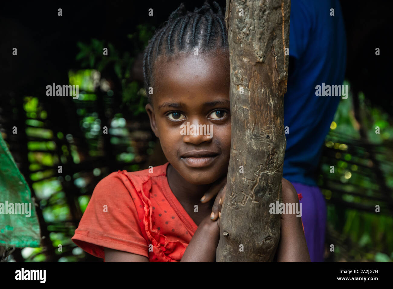 Jinka, Äthiopien - Nov 2018: Porträt der jungen äthiopischen Mädchen lehnte sich auf hölzerne Säule Stockfoto