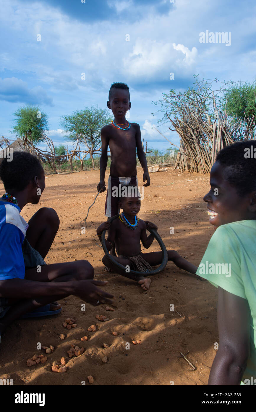 Turmi, Äthiopien - Nov 2018: Hamer Stamm Kerle spielen ein Spiel mit Steinen in den Boden. Omo Valley Stockfoto