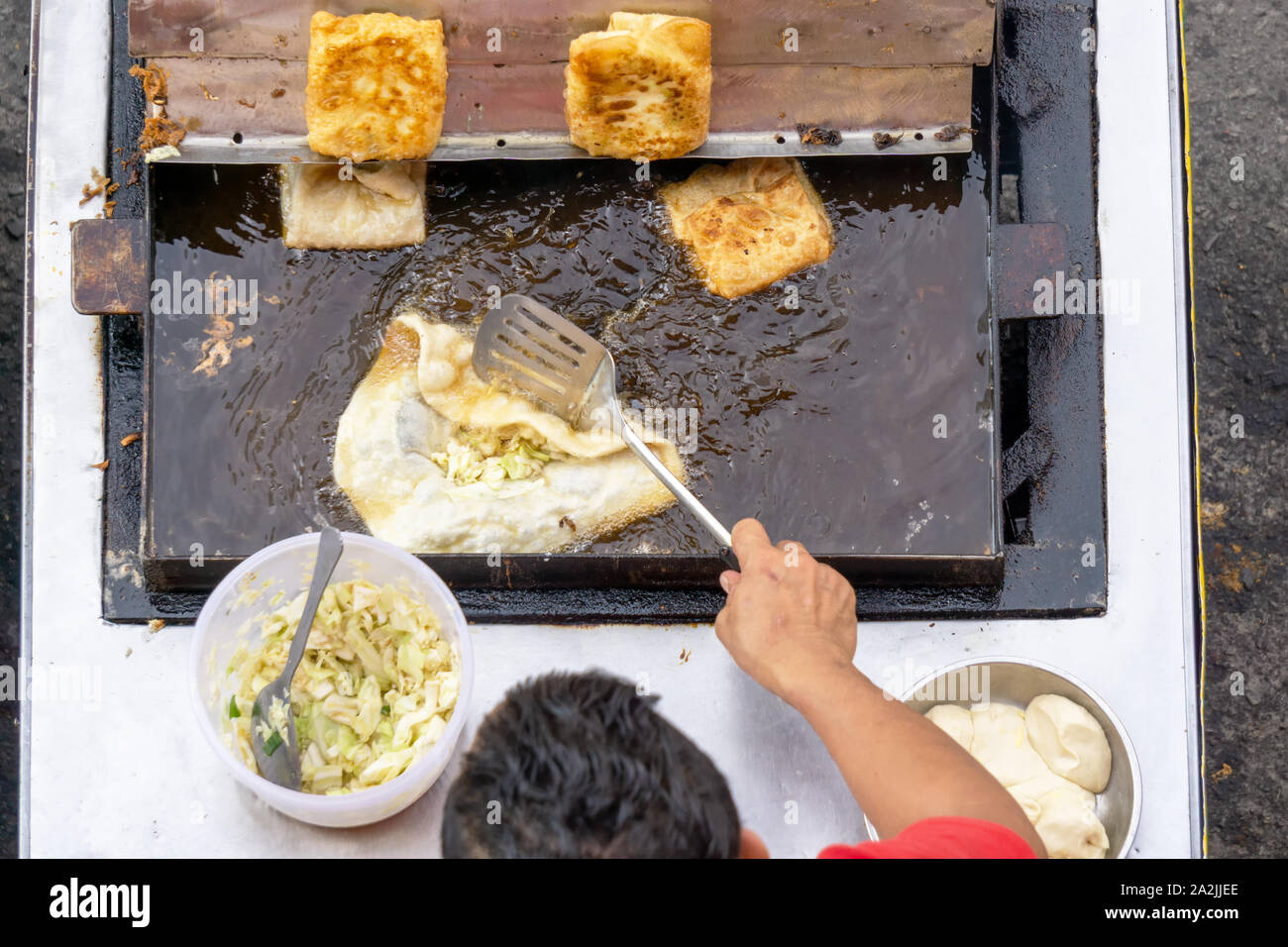 Draufsicht eines Mannes hand Kochen Gemüse Martabak Jawa in Kota Kinabalu City offenen Markt in Sabah Borneo. Martabak Jawa auch bekannt als gefüllte Pfannkuchen Stockfoto