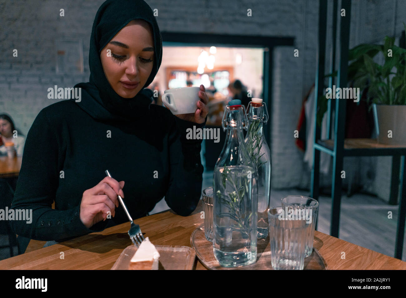 Muslimische Frau in der gemütlichen Cafe enjouing ihr Wochenende. Konzept der Lebens voller Leben mit modernen Haltung von tolerierbaren Gesellschaft. Aktiven Lebensstil Stockfoto