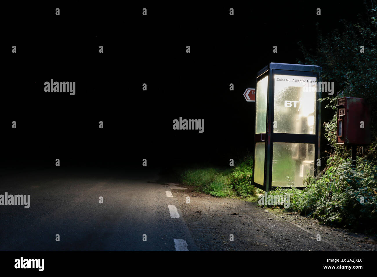 Eine öffentliche Telefonzelle entlang einer Landstraße mitten in der Nacht. Cumbria, Großbritannien. Stockfoto