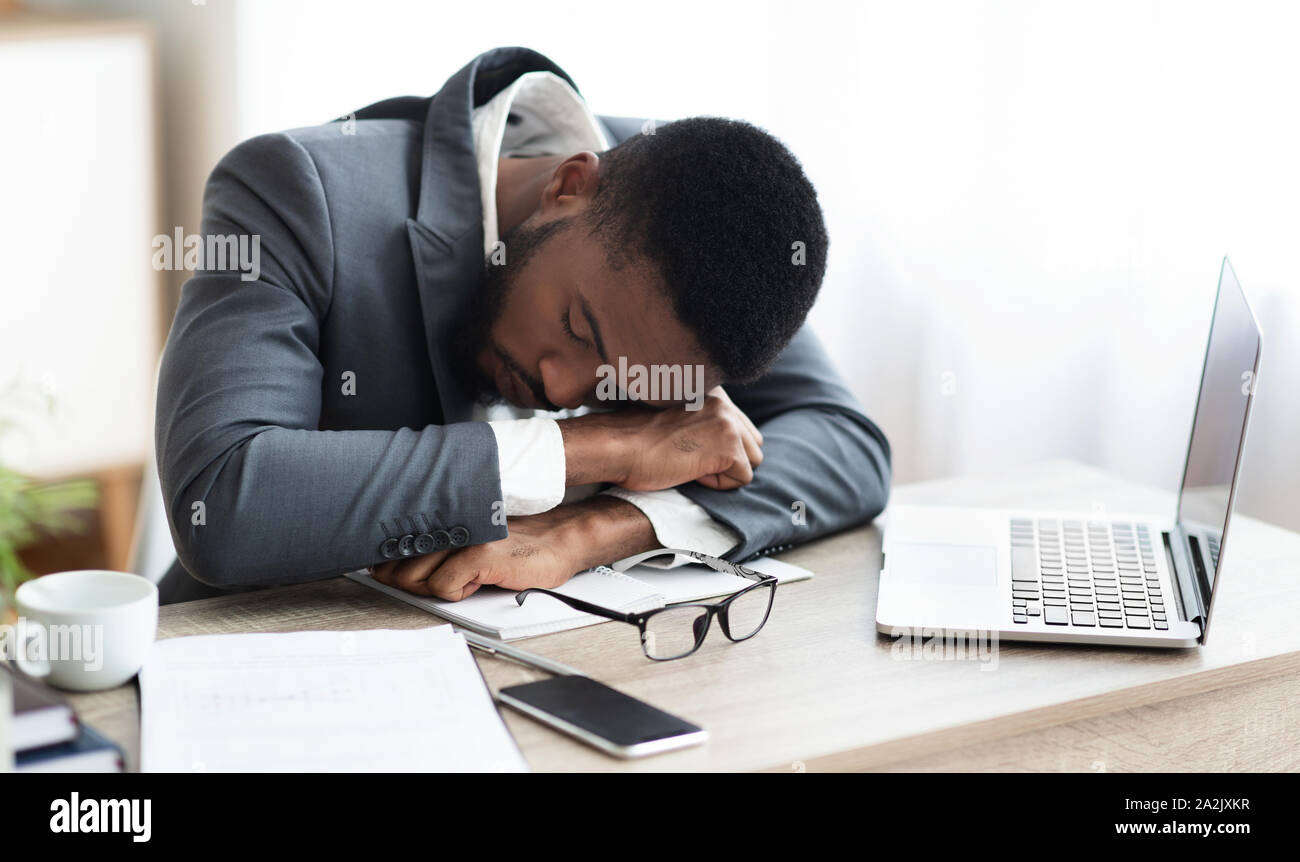 Müde afrikanische amerikanische Geschäftsmann in ein Nickerchen am Arbeitsplatz Stockfoto