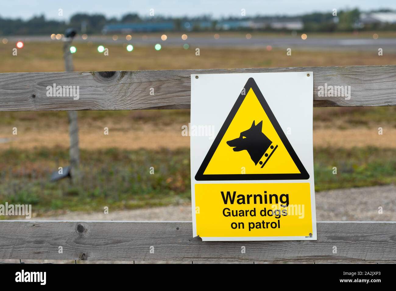 Warnung Wachhunde auf Patrouille Schild an der Umzäunung in Blackbushe Airport, UK Stockfoto