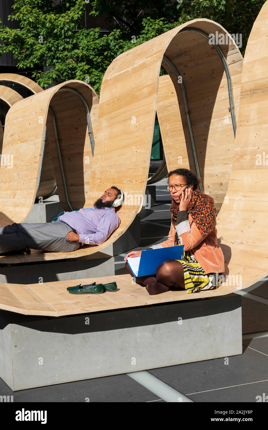 Besucher auf dem Bitte setzen Sie die Installation von Paul Cocksedge an der London Design Festival 2019 in Finsbury Avenue Square, Broadgate, London entspannen. Stockfoto