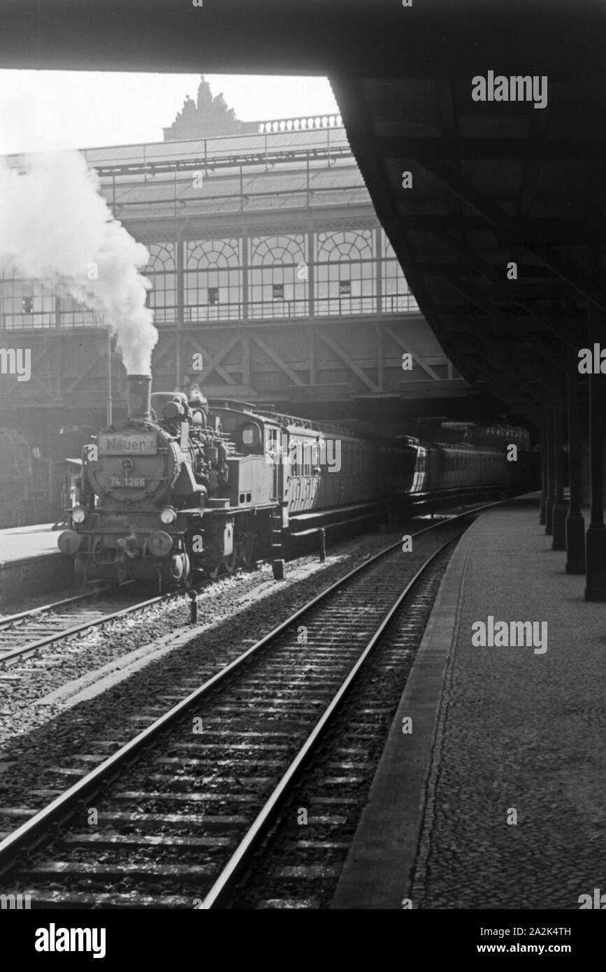 Ein Zug, der von einer Dampflokomotive der Baureihe 74 gezogen wird, verläßt den Bahnhof in Berlin, Deutschland, 1930er Jahre. Ein Zug, der mit einer Dampflok Stockfoto