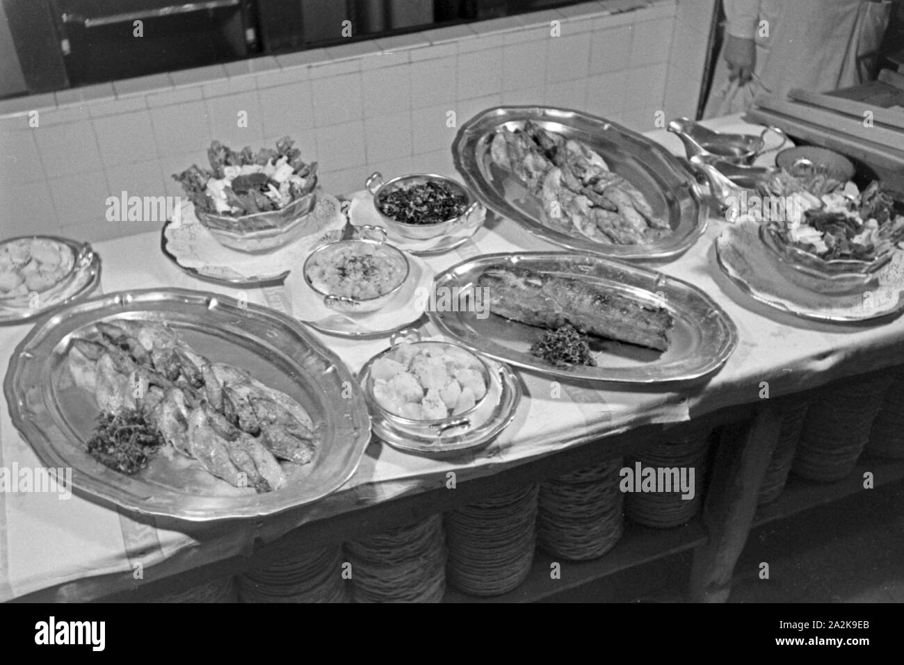 Lecker und frisch zu bereitete Mahlzeiten in der Küche einer Gaststätte, Deutschland 1930er Jahre. Lecker und frisch zubereitete Mahlzeiten in der Küche eines Restaurants, Deutschland 1930. Stockfoto