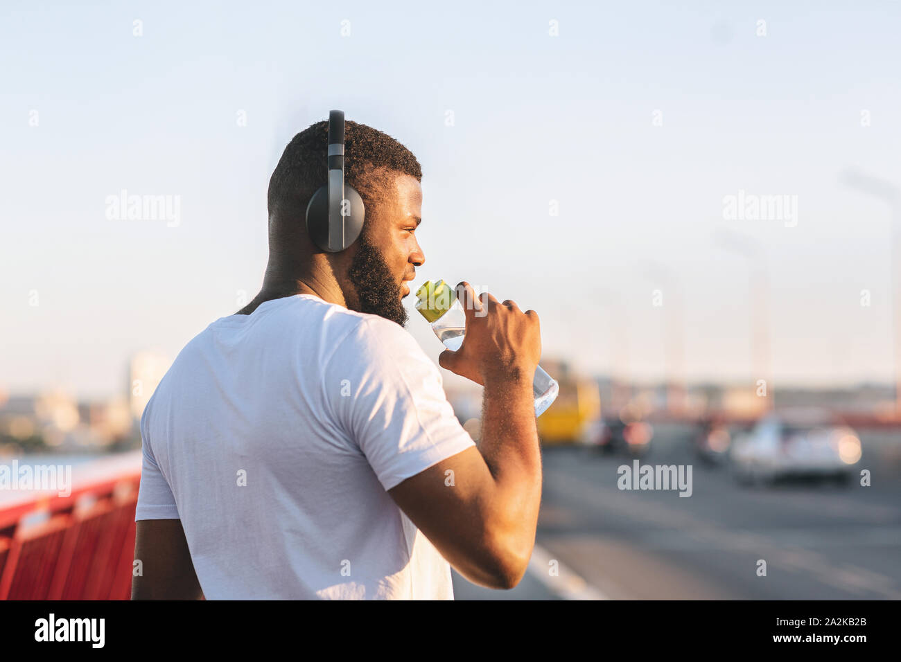 Rückansicht des afrikanischen amerikanischen Jungen Mann Trinkwasser Stockfoto