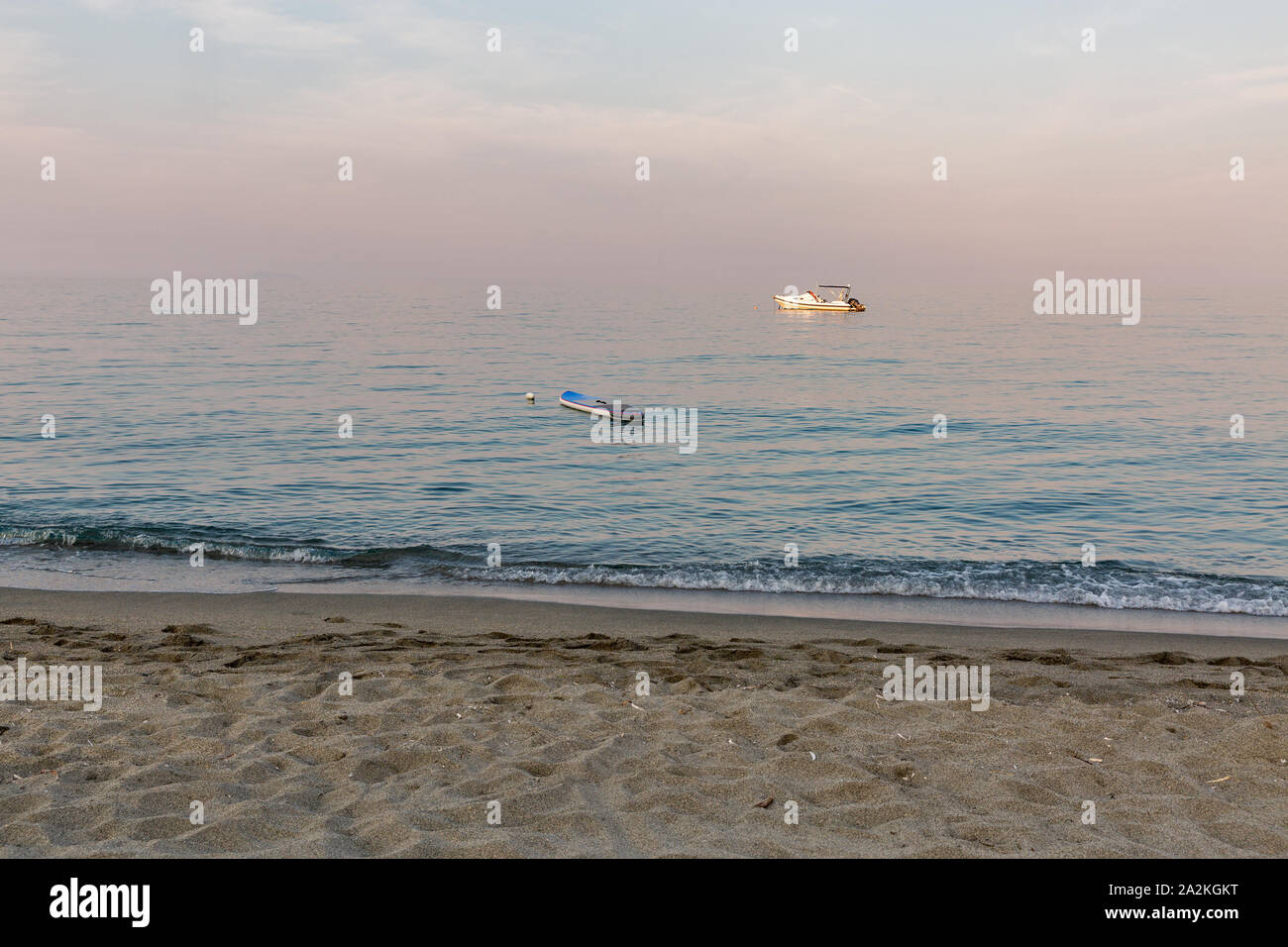 Korsika Sommer Sonnenuntergang Strand Meereslandschaft mit Boot und SUP board, Frankreich. Stockfoto