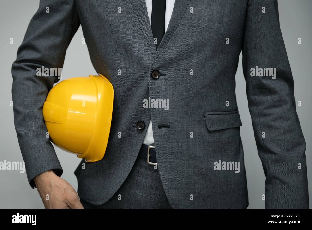 Sicherheit am Arbeitsplatz oder Bau Geschäftskonzept - Geschäftsmann Holding gelben Helm Unterarm Stockfoto