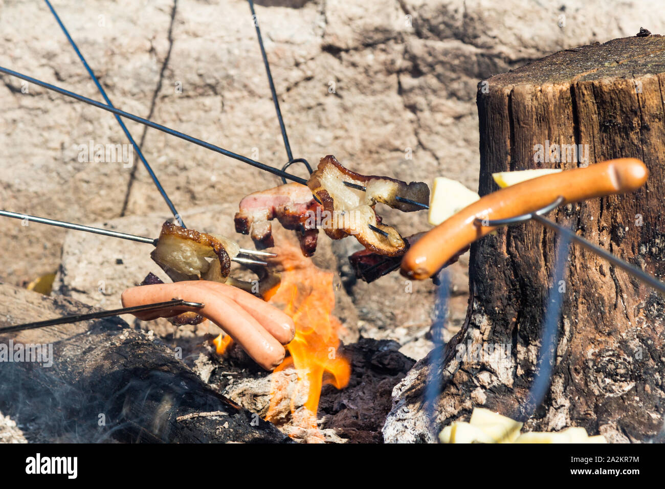 Szalonnasutes (outdoor Rösten fetten Speck und Frankfurter am Spieß) über dem Lagerfeuer Feuer in Sopron, Ungarn Stockfoto