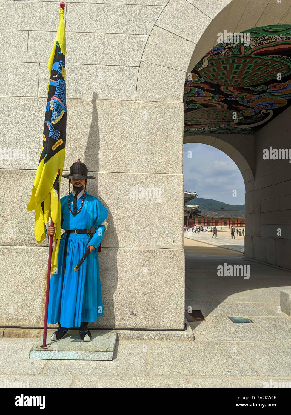 SEPT. 19, 2019 - Seoul, Südkorea: Guard trägt einen blauen traditionelle koreanische Kleidung Holding eine gelbe Flagge stehen noch am Eingang des Gyeongb Stockfoto