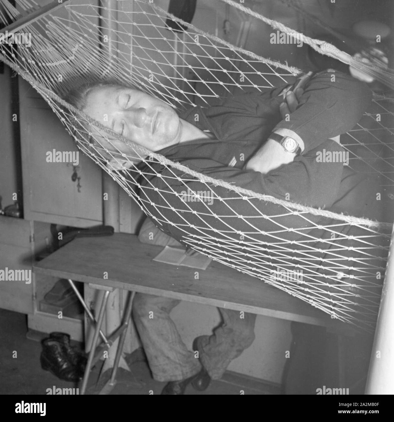 Original-Bildunterschrift: Freizeit des Matrosen: schlafen nach anstrengendem Dienst ein Bord eines Torpedoboots, Deutschland 1940er Jahre. Sailor's Freizeit: Schlafen unter Deck eines Torpedoboot, Deutschland 1940. Stockfoto
