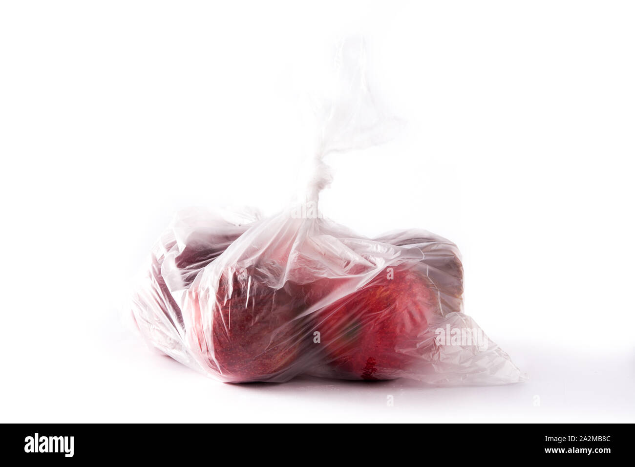 Rote Äpfel in Plastikbeutel verpackt auf weißem Hintergrund Stockfoto