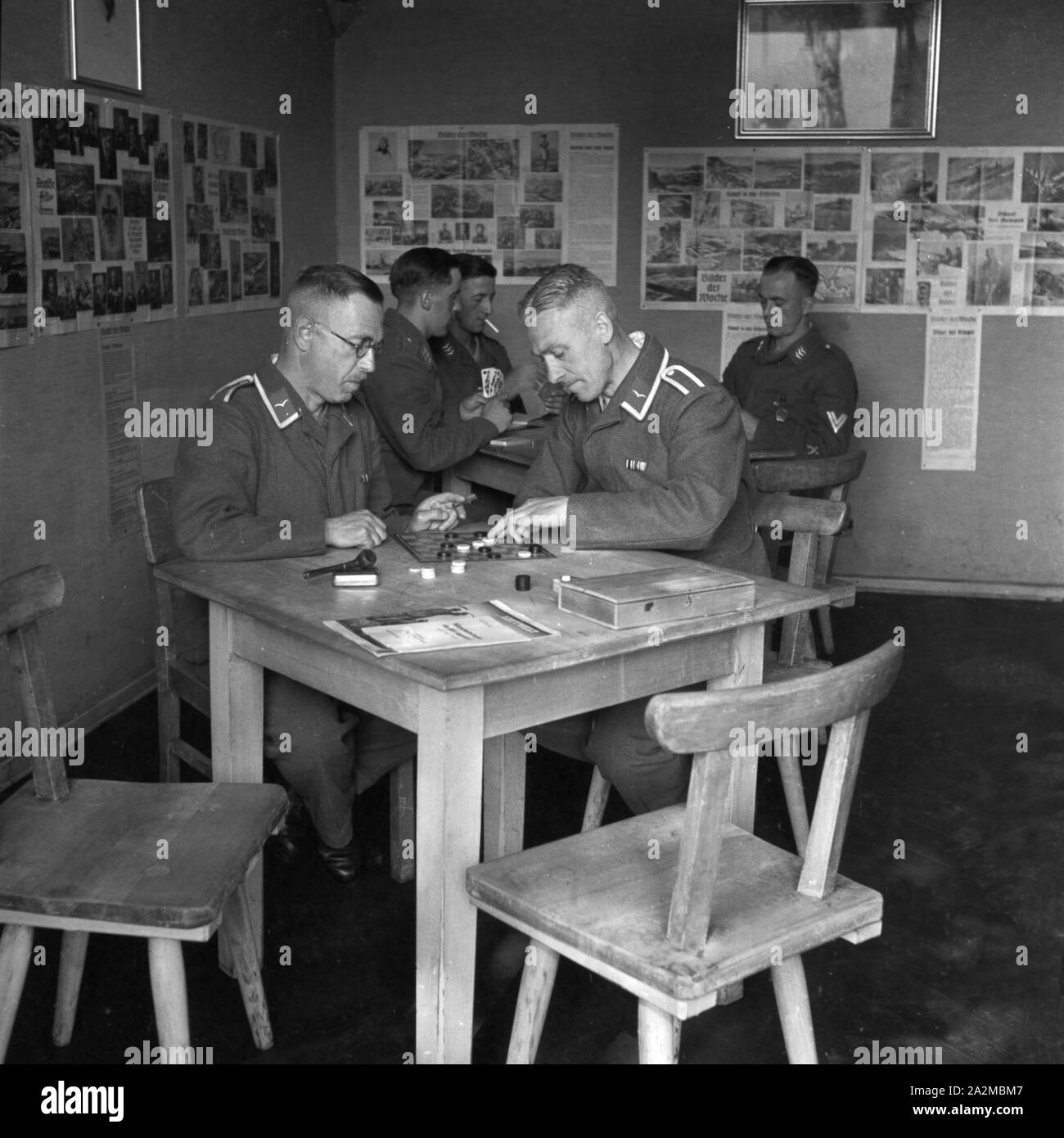 Original-Bildunterschrift: Freizeit in der Kaserne - damespielen im Gemeinschaftsraum, Deutschland 1940er Jahre. Freie Zeit in der Kaserne - Spielen der Entwürfe im Aufenthaltsraum, Deutschland 1940. Stockfoto
