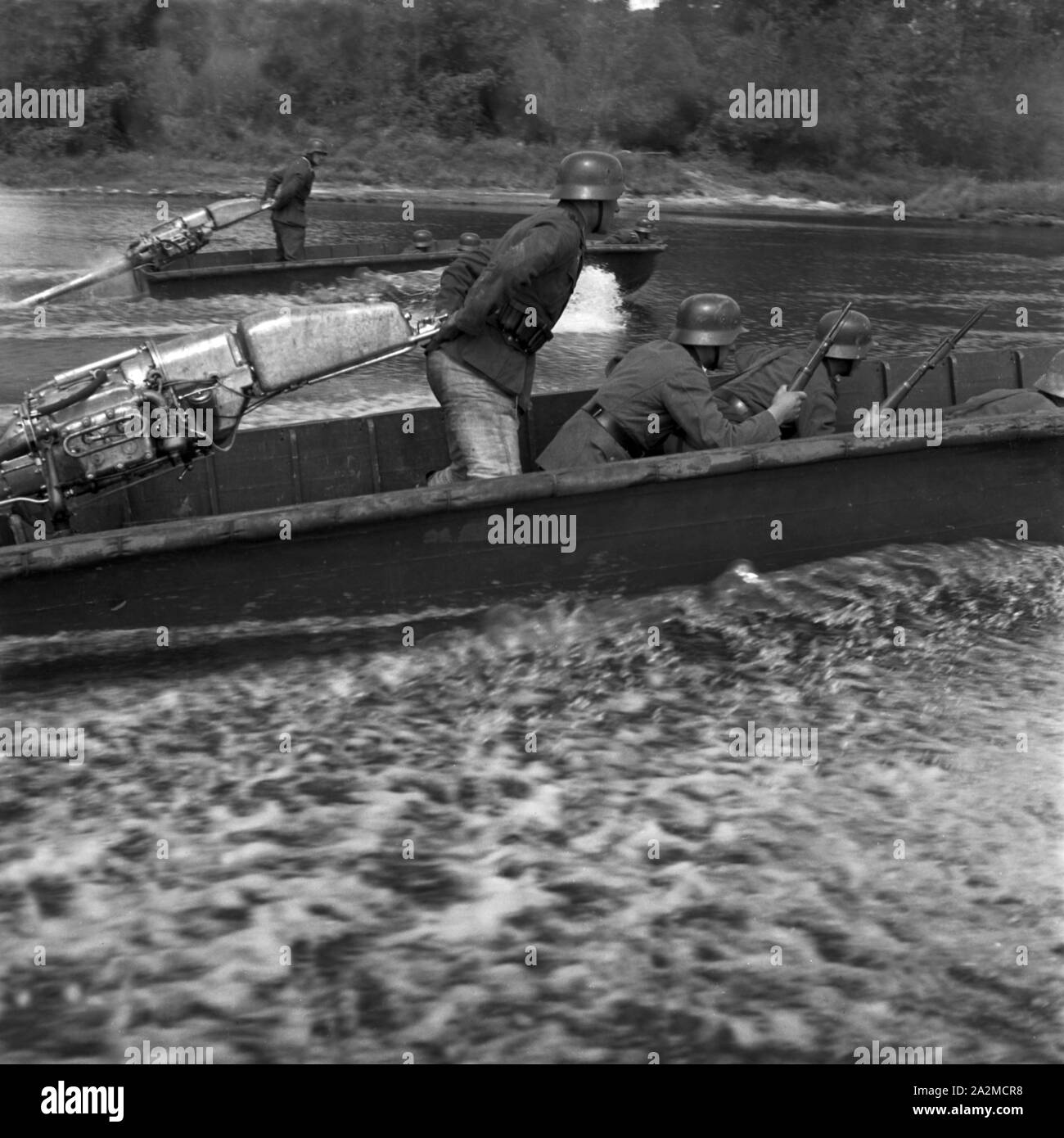Original-Bildunterschrift: Strumboote bringen Pionier Stoßtrupps ans Ufer, um feindliche Stellungen zu bekämpfen, Deutschland 1940er Jahre. Angriff Boote tragen Militärtechnik Truppen zu einer feindlichen Ufer, um feindliche Stellungen kämpfen, Deutschland 1940. Stockfoto