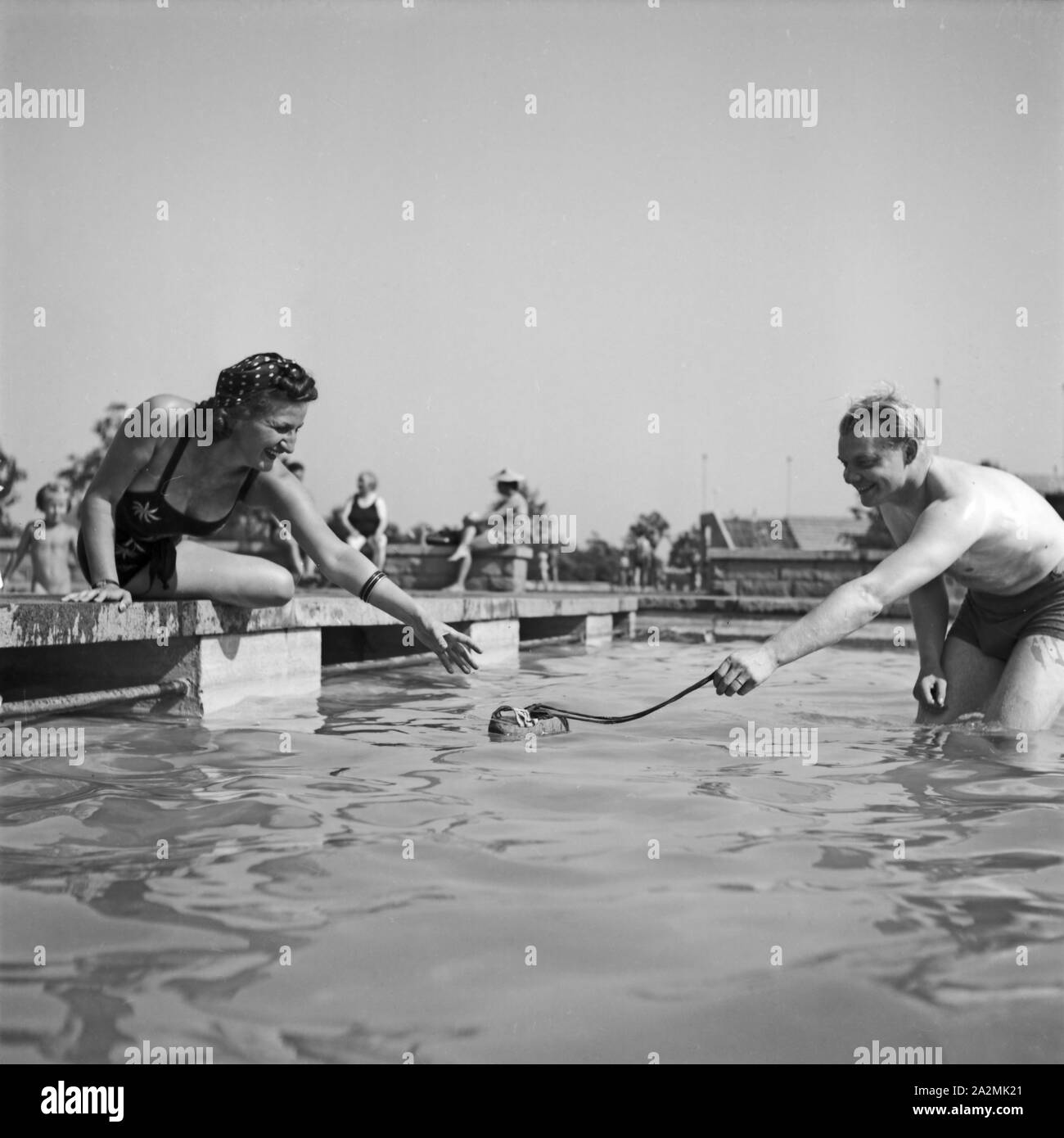 Eine Frau Und Ein Mann Kühlen Sich Ab in Einem Schwimmbad in Bad Rippoldsau-Schapbach Im Schwarzwald, Deutschland, 1930er Jahre. Eine Frau und ein Mann, kühlen sich in einem öffentlichen Schwimmbad in Bad Rippoldsau-Schapbach im Schwarzwald, Deutschland der 1930er Jahre. Stockfoto