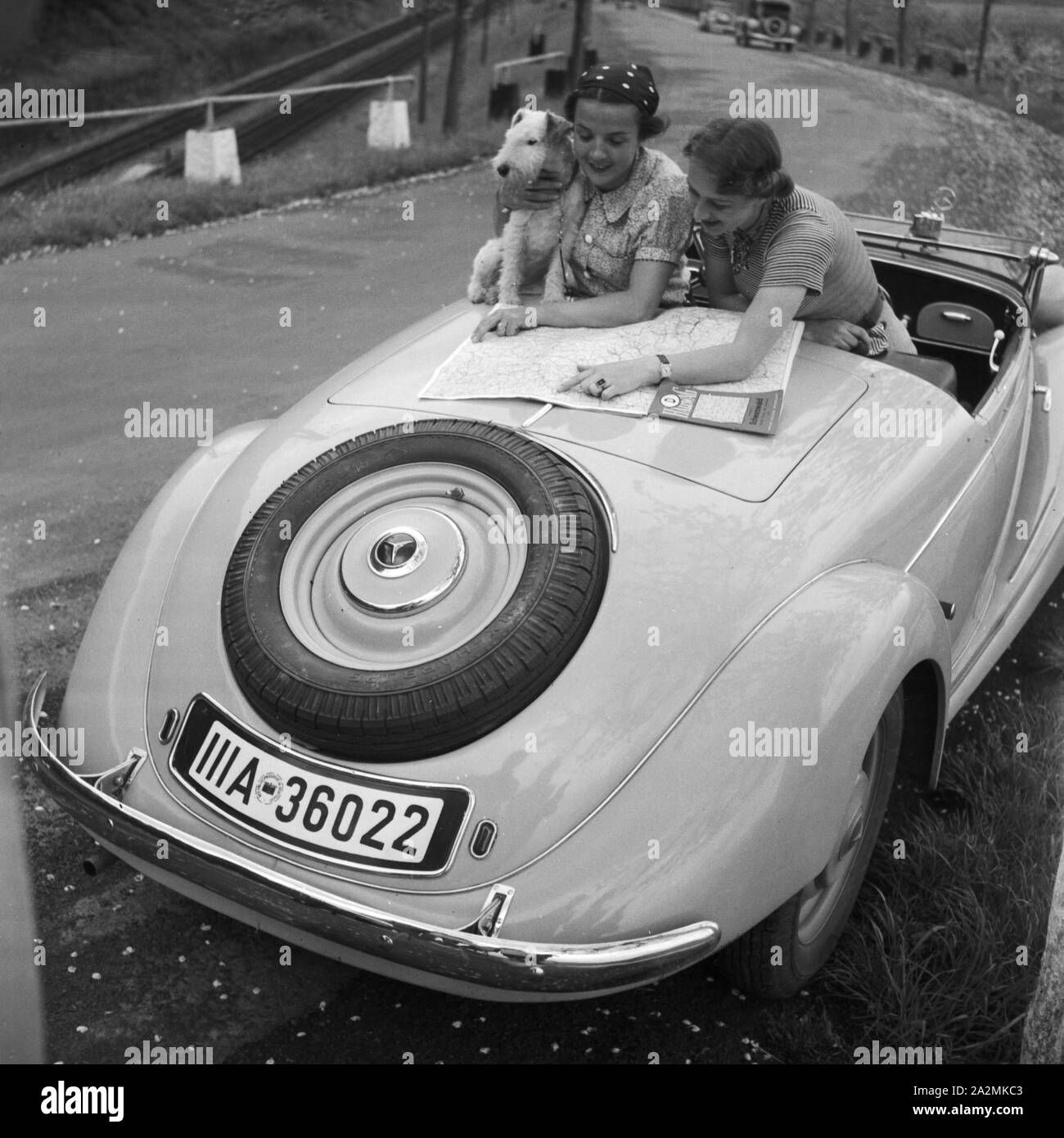 Zwei Frauen ein 1963 Mercedes Benz Cabrio, Deutschland 1930er Jahre. Zwei Frauen mit einem Mercedes Benz Cabrio, Deutschland 1930. Stockfoto