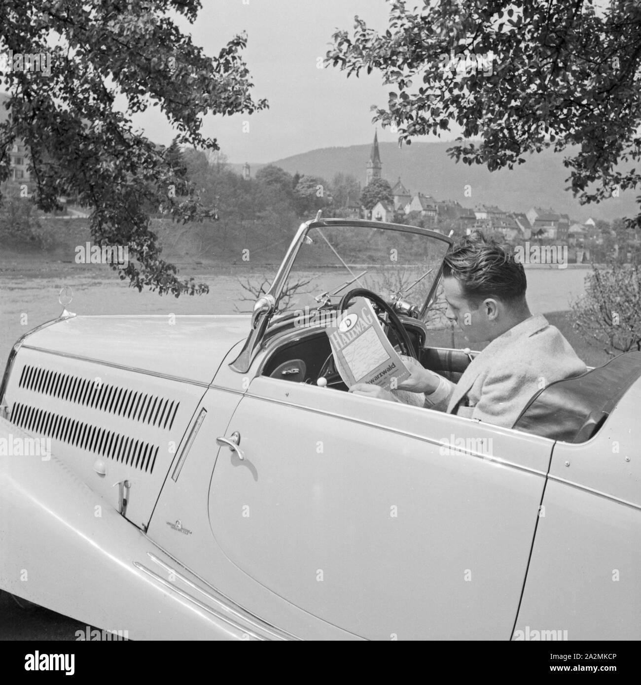 Ein Mann in einem Mercedes Benz Cabrio vor Neckargemünd bei Heidelberg, Deutschland 1930er Jahre. Ein Mann in seinem Mercedes Benz Cabrio in Neckargemuend in der Nähe von Heidelberg, Deutschland 1930. Stockfoto