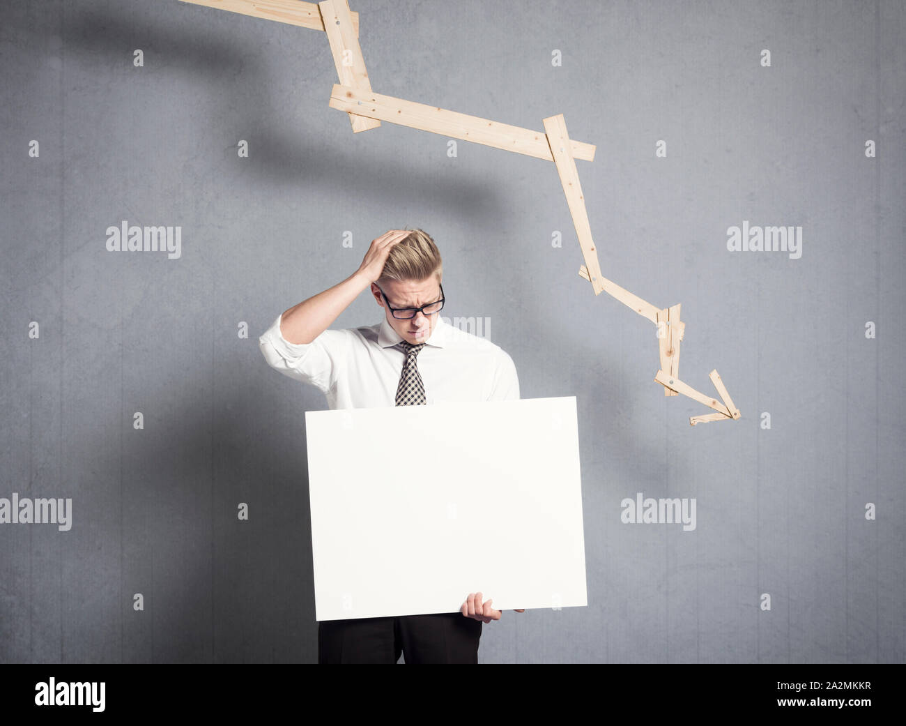 Frustriert Geschäftsmann holding Verkleidung vor Grafik unten zeigt. Stockfoto