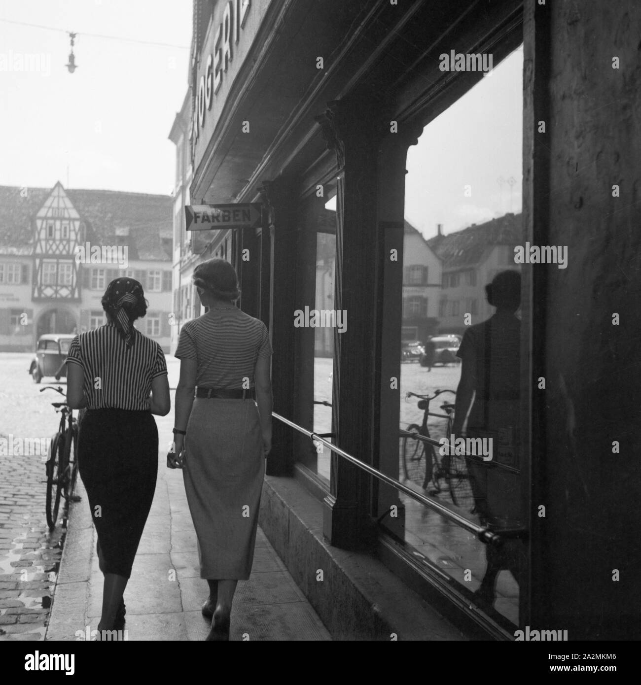 Zwei Frauen unheimlich bin-Schaufenster einer Drogerie vorbei, Deutschland 1930er Jahre. Zwei Frauen, die im Schaufenster einer Apotheke, Deutschland 1930. Stockfoto