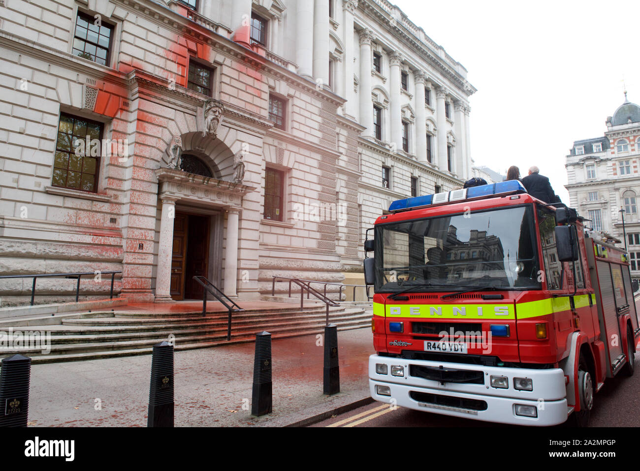 London, Großbritannien. 3. Oktober 2019. Aussterben Rebellion Aktivisten der Fire Engine Spray zu 1.800 Liter Fake Blood über der Vorderseite des Treasury in LondonThe protest Highlights die Inkonsistenz zwischen dem Drängen der britischen Regierung, dass das Vereinigte Königreich ist weltweit führend bei der Bekämpfung des Klimawandels Zusammenbruch, und die beträchtliche Summen in die Exploration fossiler Brennstoffe und CO2-intensive Projekte gießt. Kredit Gareth Morris/Alamy leben Nachrichten Stockfoto