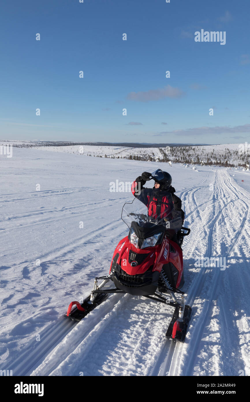 Woman-driving Snowmobile bei arktischen Winterlandschaft Lapplands Stockfoto