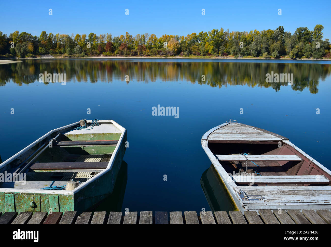 Herbst Landschaft. Ein See, ein Boot Brücke und zwei Boote mit gelben und grünen Bäumen im Hintergrund. 68782 Bruehl, Baden-Württemberg, Deutschland. Stockfoto