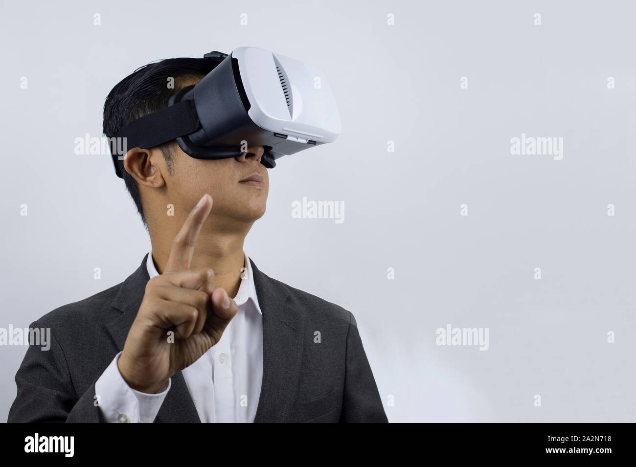 Mann in einem Anzug mit Virtual reality Brillen auf seinem Kopf. Auf weissem Hintergrund. (Selec tive fogus) Stockfoto
