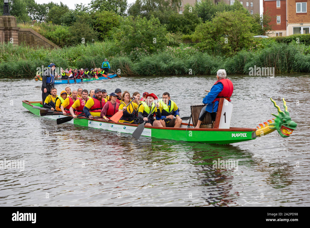 Die Teams kommen zu den Fluss am Ende des Dragon Boat Race 2019 zugunsten der St. Rocco's Hospice, gehalten am Ruderverein in Warrington, Cheshire, Engla Stockfoto