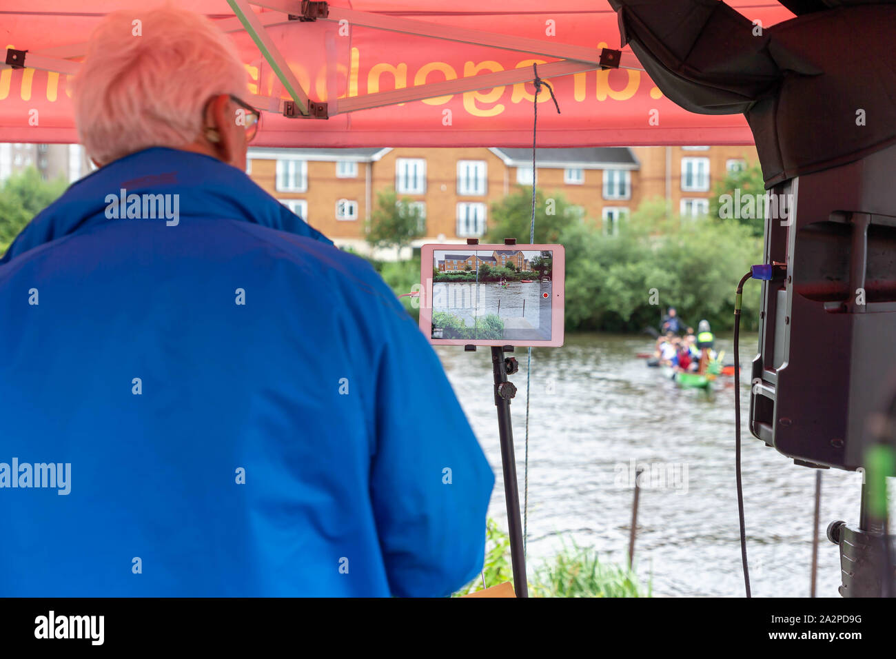 Timekeeper prüft die Ziellinie auf seinem Tablet an einem Drachenbootrennen 2019 zugunsten der St. Rocco's Hospiz, am Ruderverein in Warrington, Cheshire, Ger gehalten Stockfoto