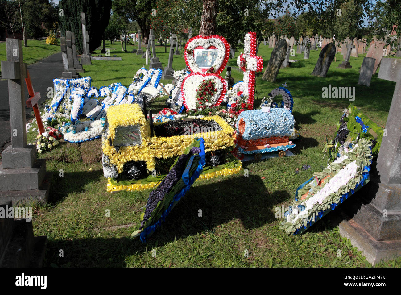 Eine deutlich gestaltete Grab mit einem floralen Ford Lkw im Vordergrund. Stockfoto