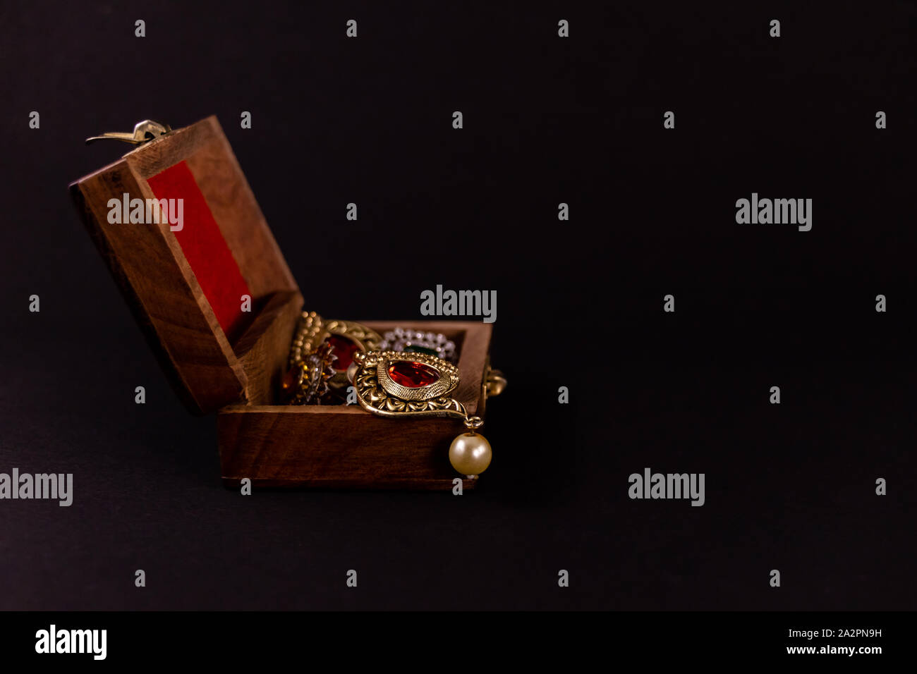Satz von Golden Earing in Holz- Geschenkbox auf dunklem Hintergrund. Traditionelle Earing Geschenk Konzept Stockfoto