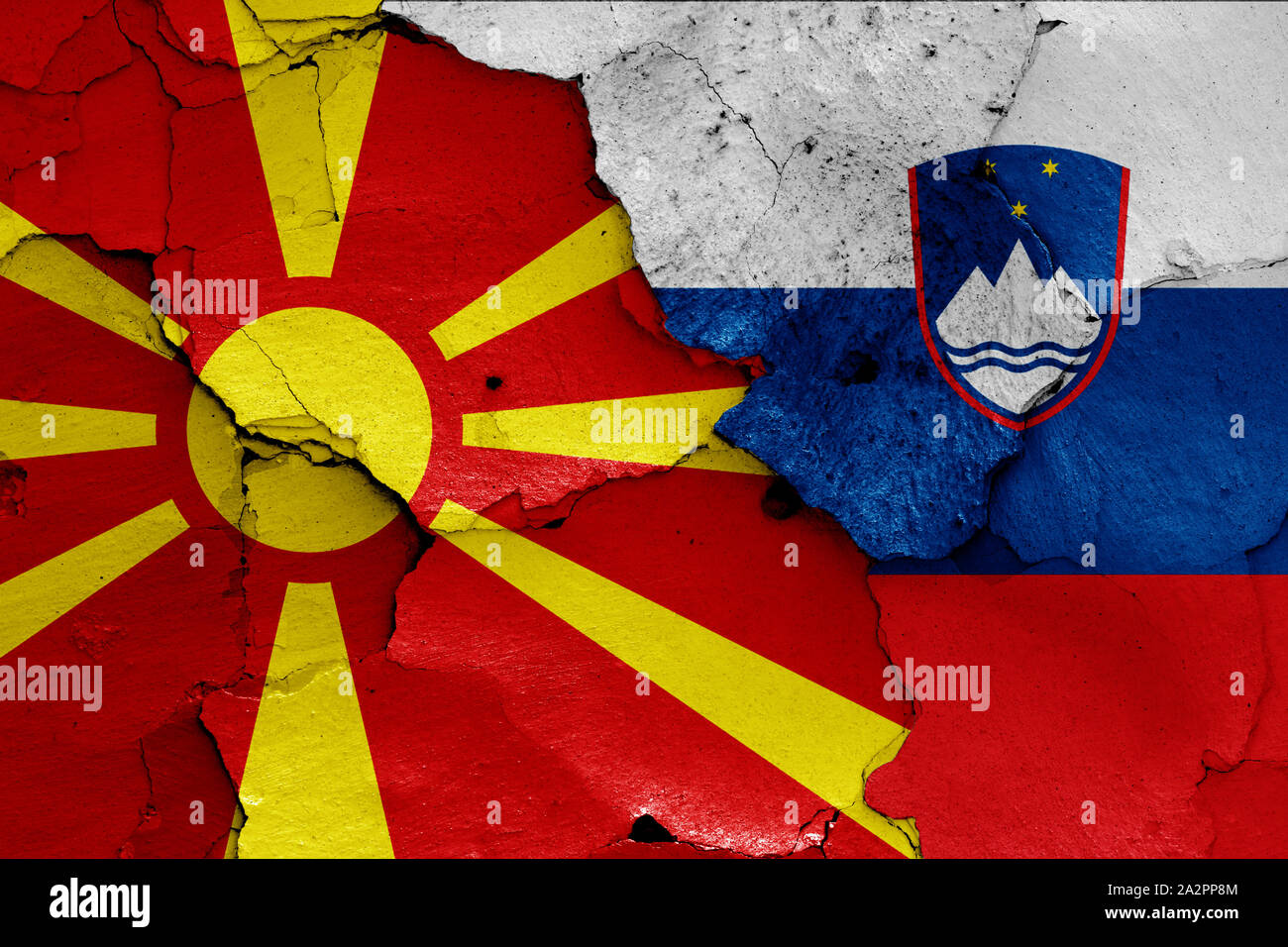 Flaggen in Mazedonien und Slowenien auf gerissene Wand gemalt Stockfoto