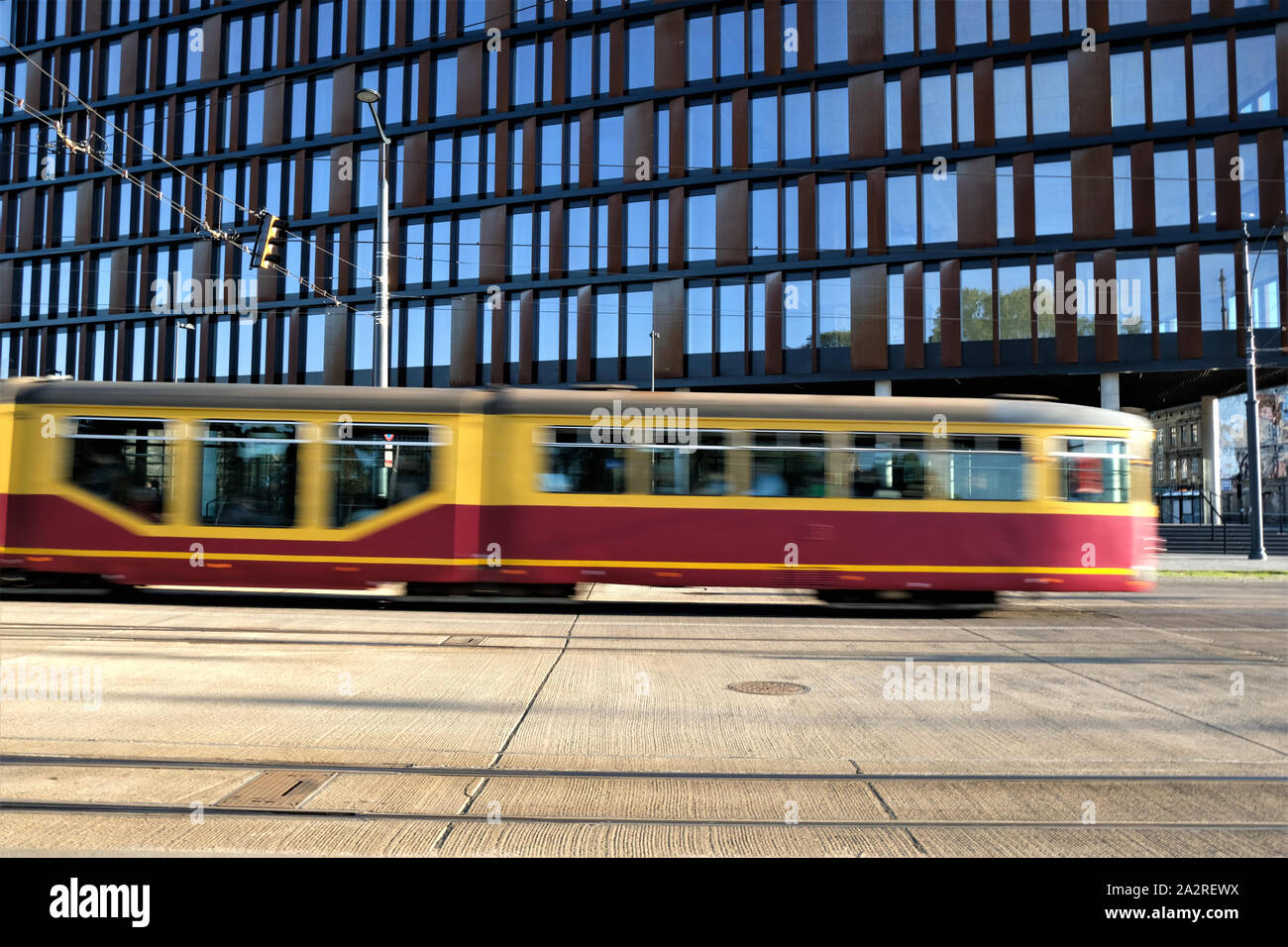 09/22/2019 in Lodz, Polen, gelben Straßenbahn in Bewegung in der Straße ein modernes Bürogebäude "City Gate' Stockfoto