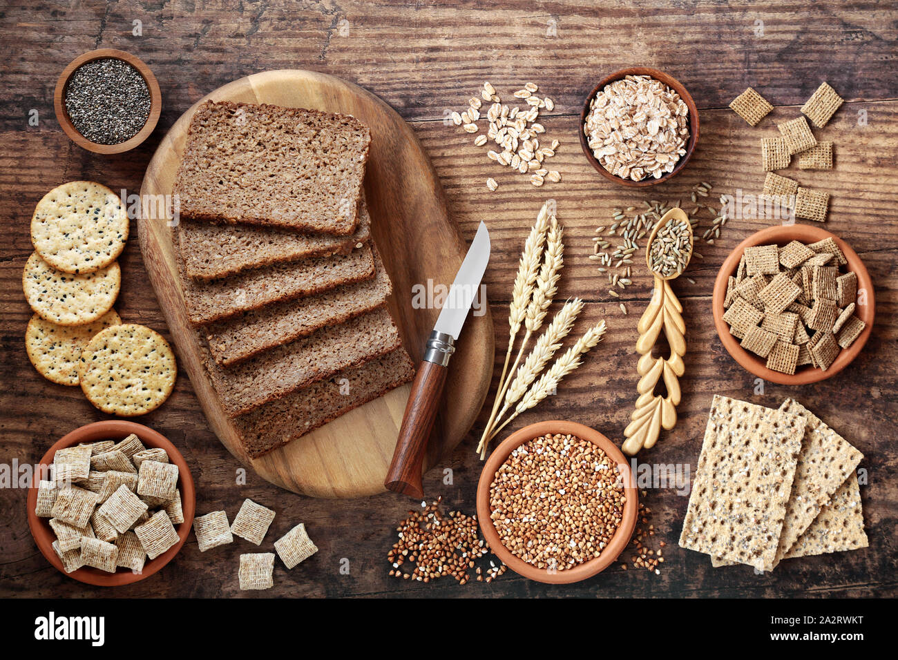 Ballaststoffreiche Ernährung mit Vollkorn Roggenbrot, gesät Cracker, Getreide, Körner, Buchweizen, Gerste Flocken und Samen. Stockfoto