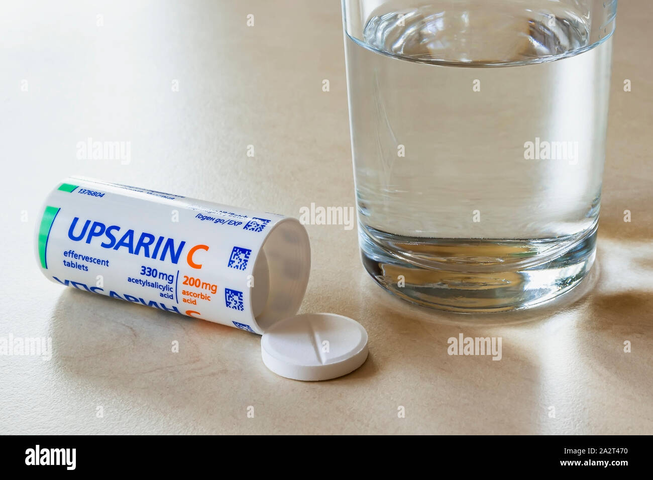 Varna, Bulgarien, Oktober 02, 2019. Upsarin C fiebersenkende Tabletten und ein Glas Wasser auf einem weißen Tisch. Löslichen Brausetabletten Aspirin mit Vitamin C. Stockfoto