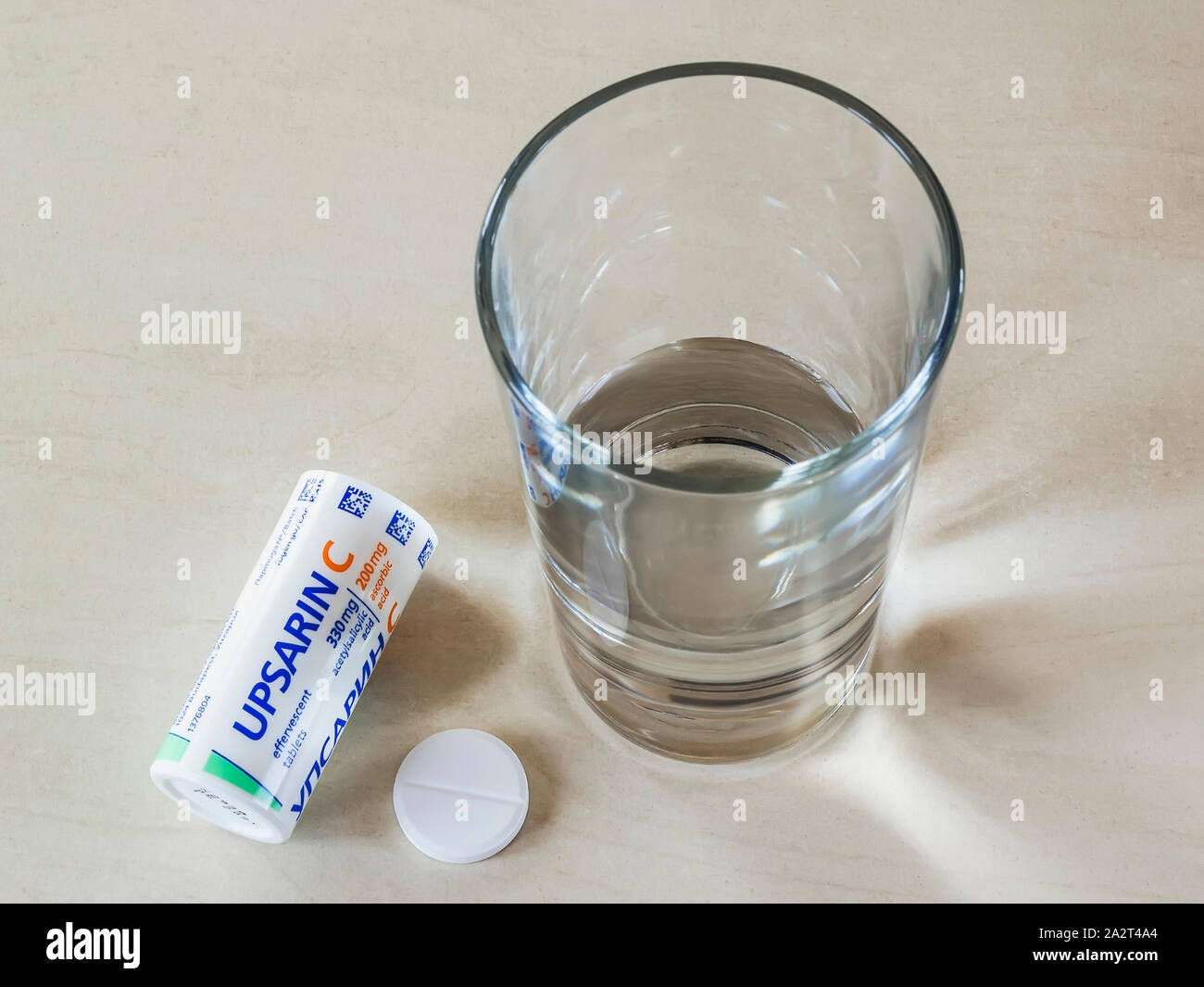 Varna, Bulgarien, Oktober 02, 2019. Blick von oben auf die UPSARIN C fiebersenkende Tabletten und ein Glas Wasser auf einem weißen Tisch. Löslichen Brausetabletten Aspirin. Stockfoto