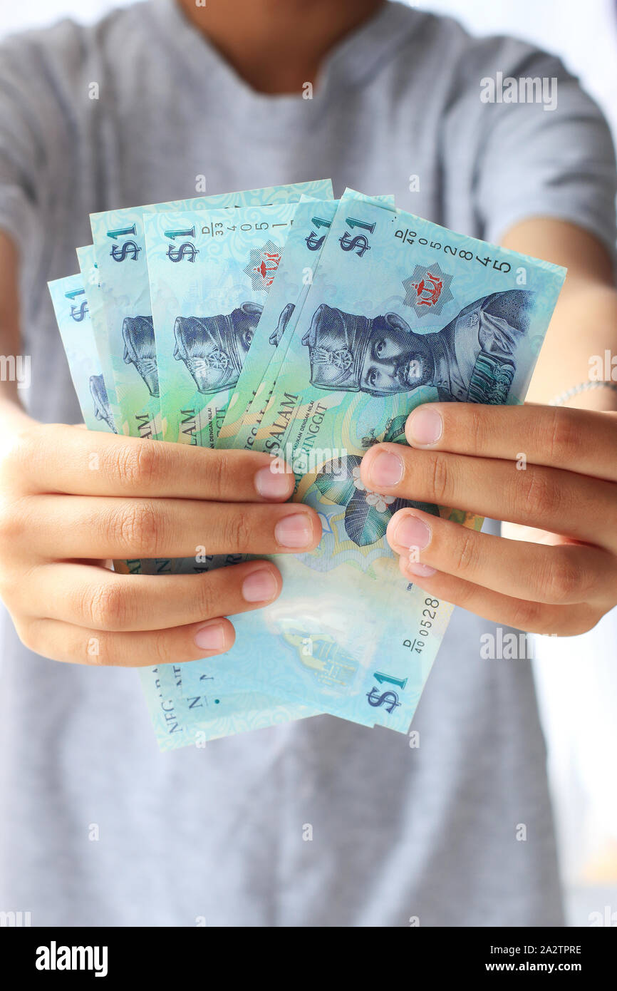 Hand mit $ 1 Brunei Dollar Stockfoto