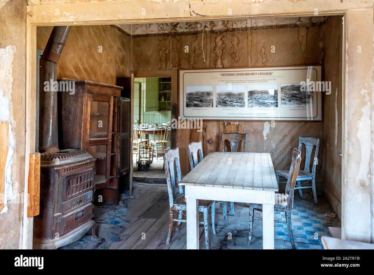 Innerhalb der Tom Miller Haus in Bodie. Blick auf den Speisesaal mit Herd und Tisch, in der Küche durch die Tür sichtbar. Stockfoto