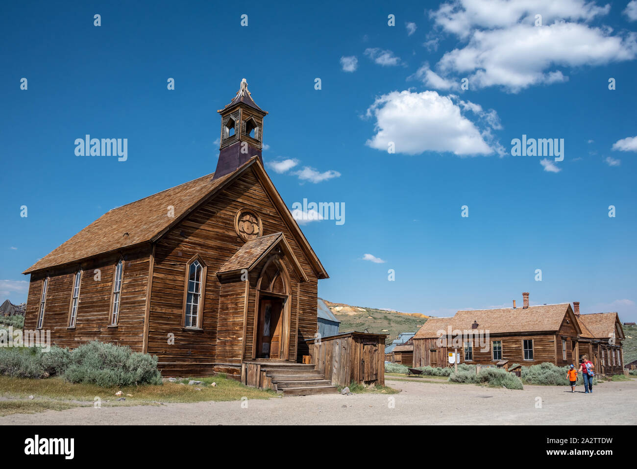 Alte methodistische Kirche Außenansicht bei Bodie mit Besuchern zu Fuß die Straße runter von der Geisterstadt in der östlichen Sierra von Kalifornien. Stockfoto