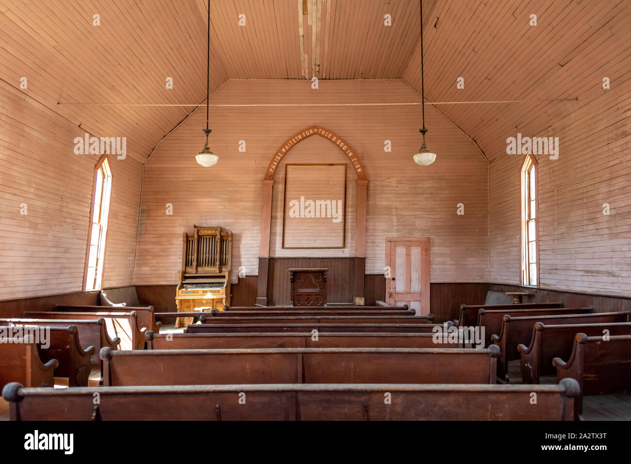 Innerhalb der alten Methodistischen Kirche an Bodie State Historic Park, in Kalifornien, mit Reihen der Bänke und kleine Kirche Orgel (zentriert). Stockfoto